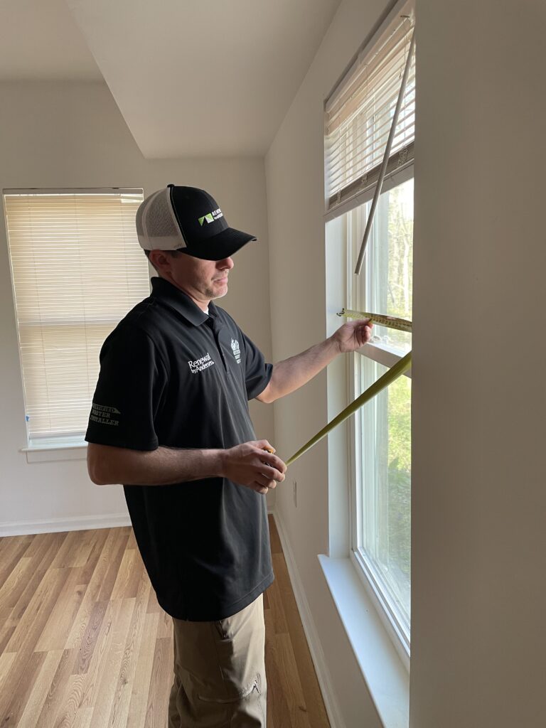Renewal by Andersen measures the old windows.