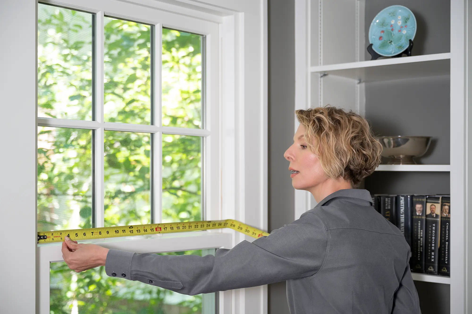 Renewal by Andersen employee measuring a window