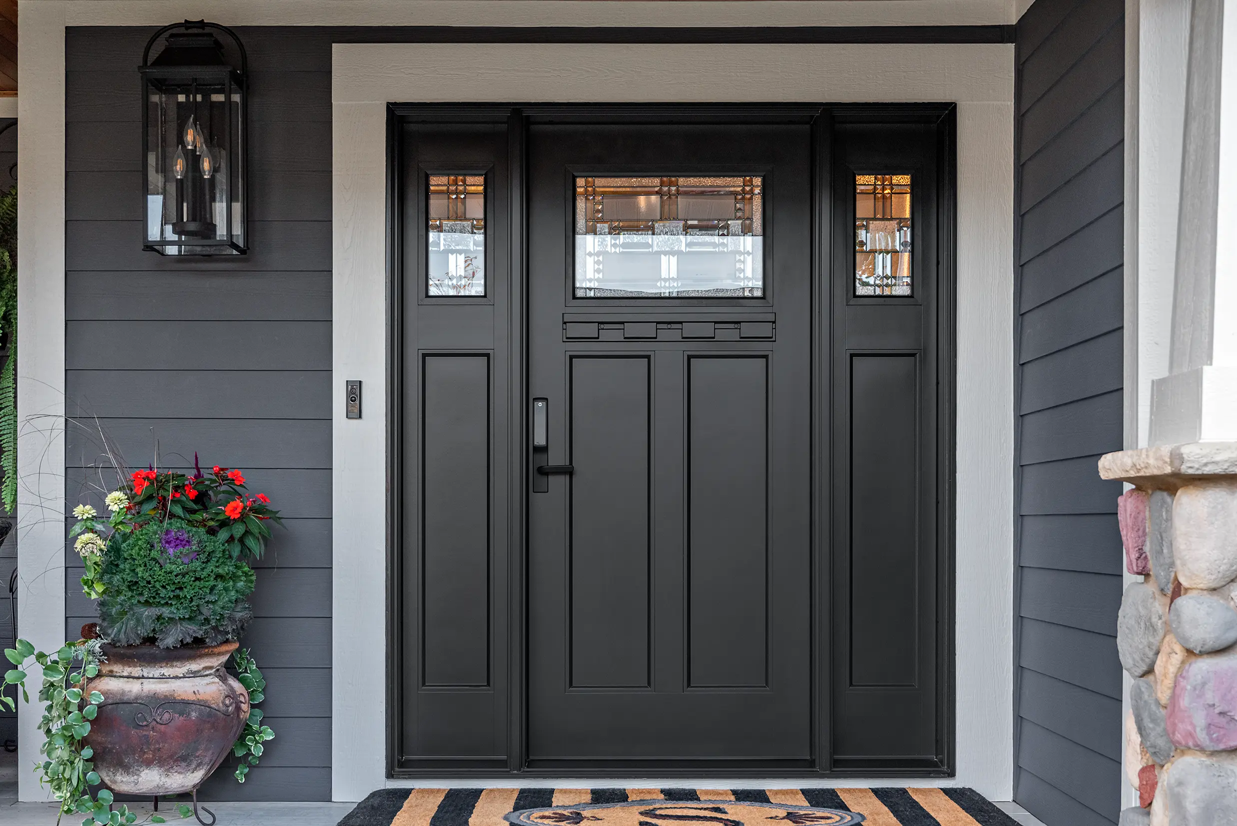 Black door with window insert and side panels with small windows