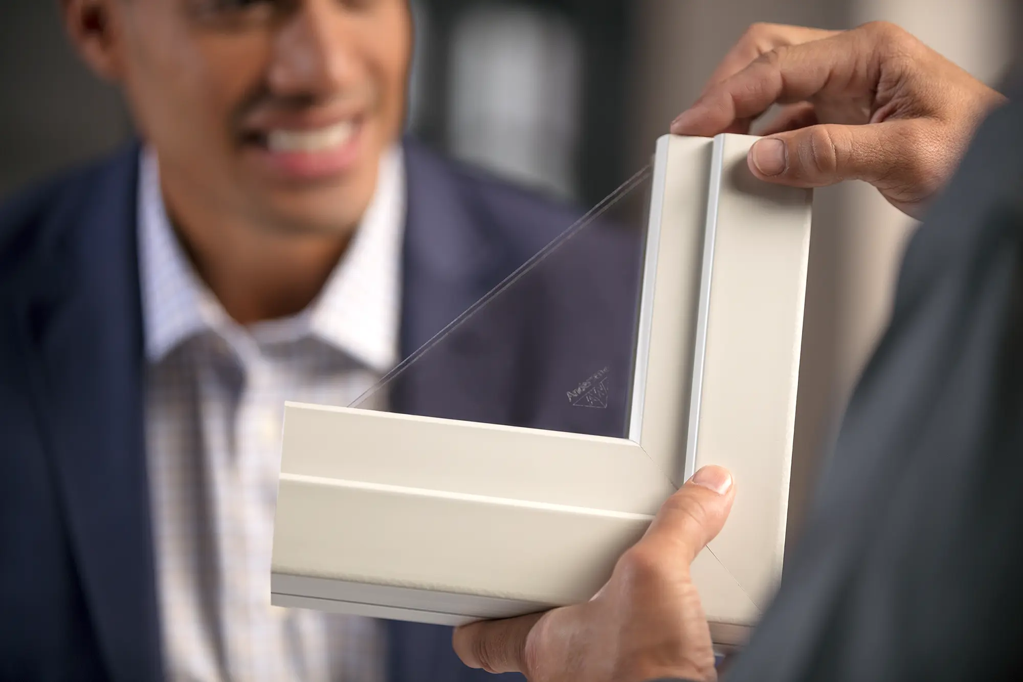 Hand showing a man the Fibrex interior of a window