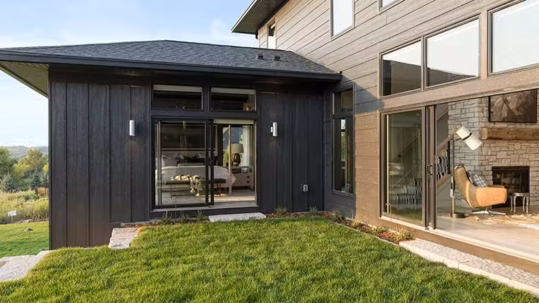 Black gliding patio doors leading to yard