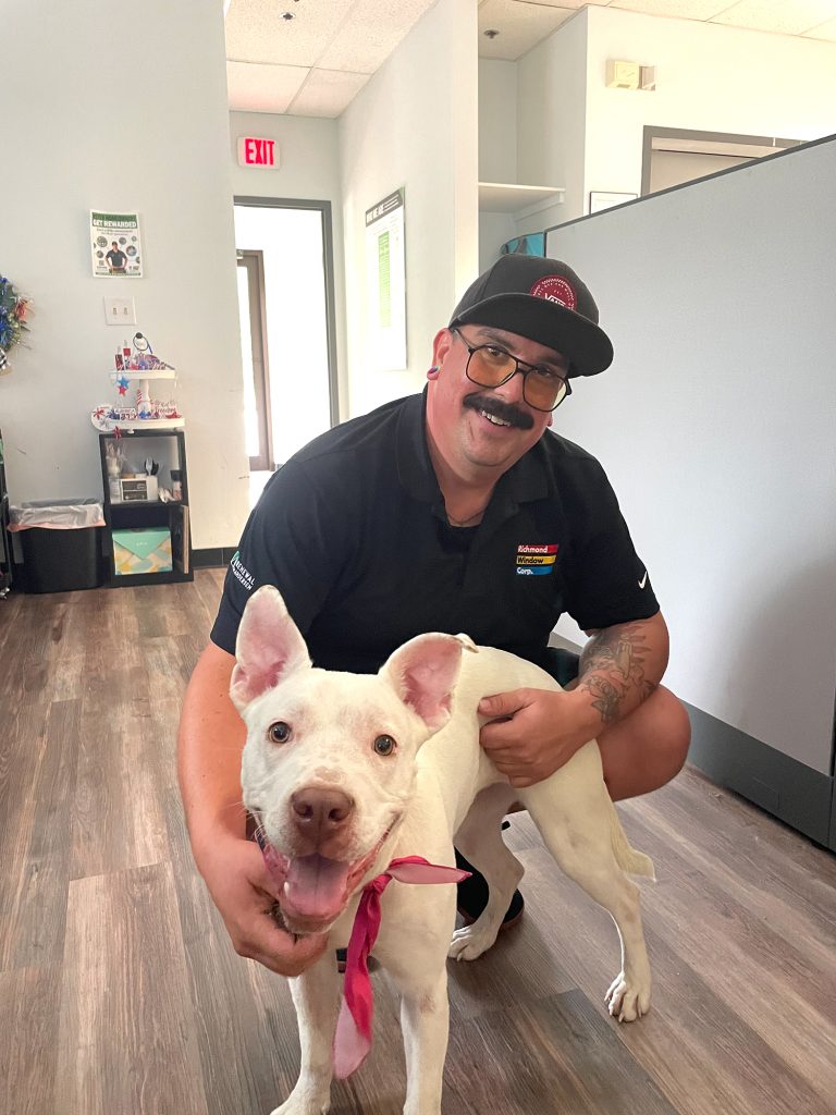 Renewal by Andersen employee smiling with a dog