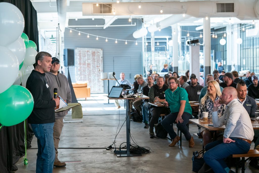 Two people presenting to a large group