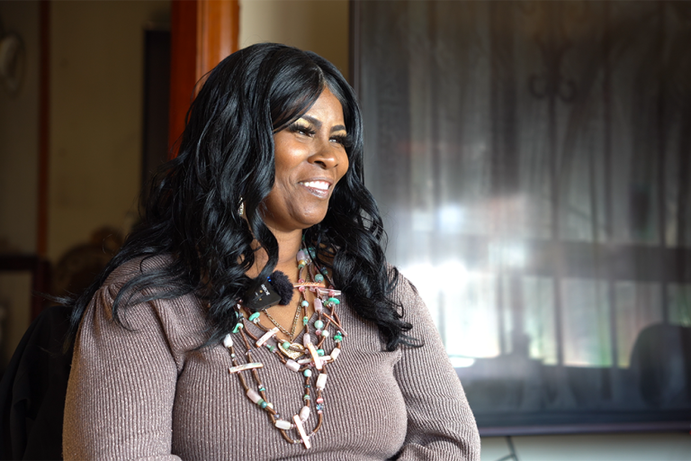 Smiling woman with a window behind her