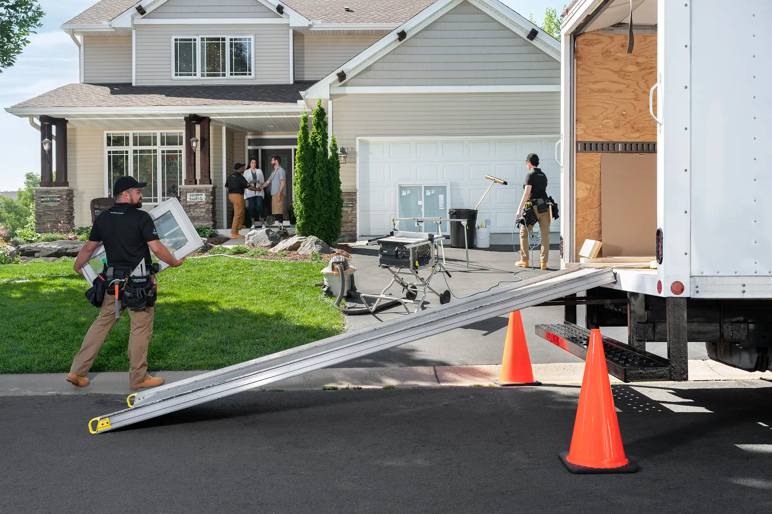 Employees installing windows at a house