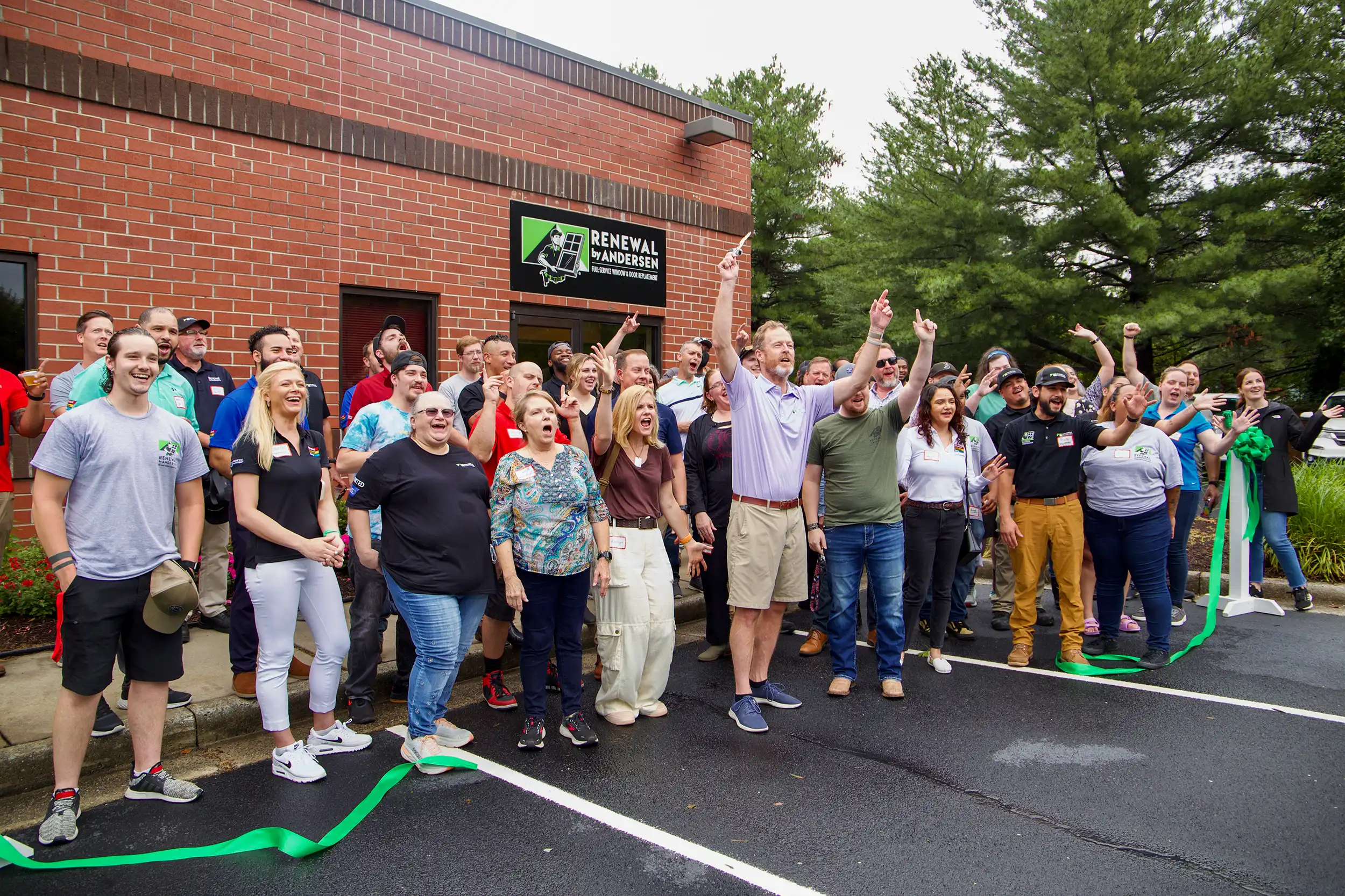Renewal by Andersen team celebrating outside of their office