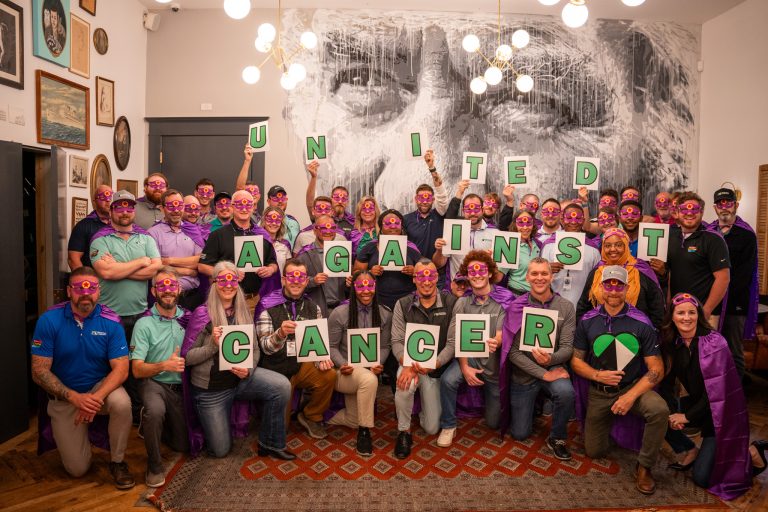 Group of people holding letters that spell out United Against Cancer