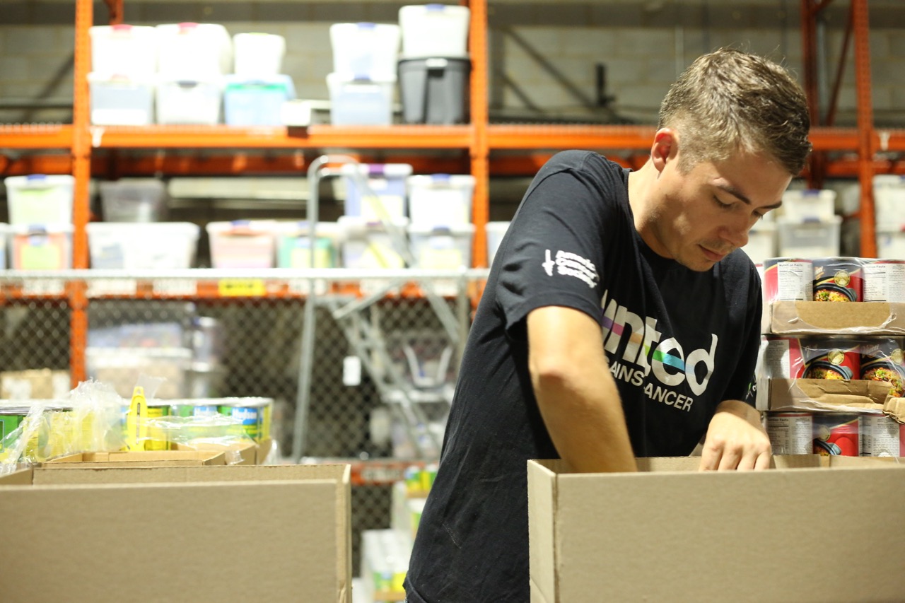 Man reaching into a box in a warehouse