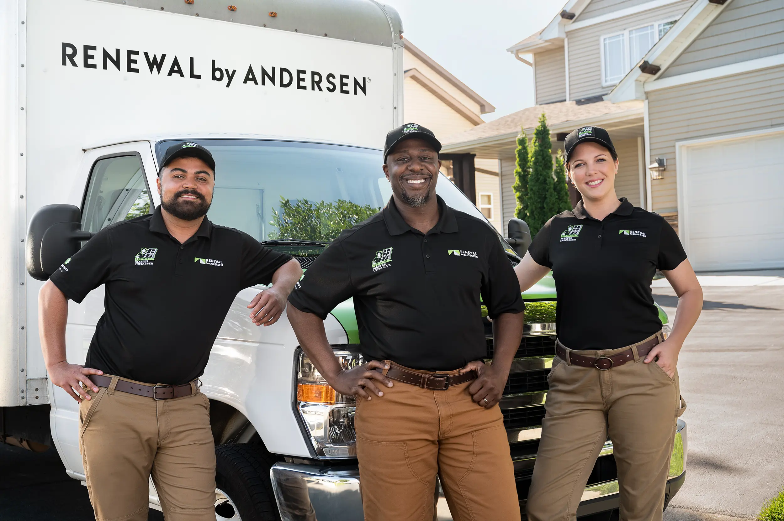 Renewal by Andersen employees leaning on a truck outside of a house