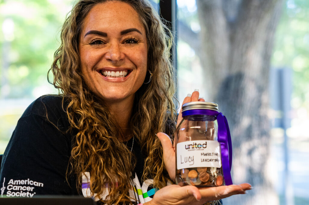 Lucy O'Shields holding a United Against Cancer change jar