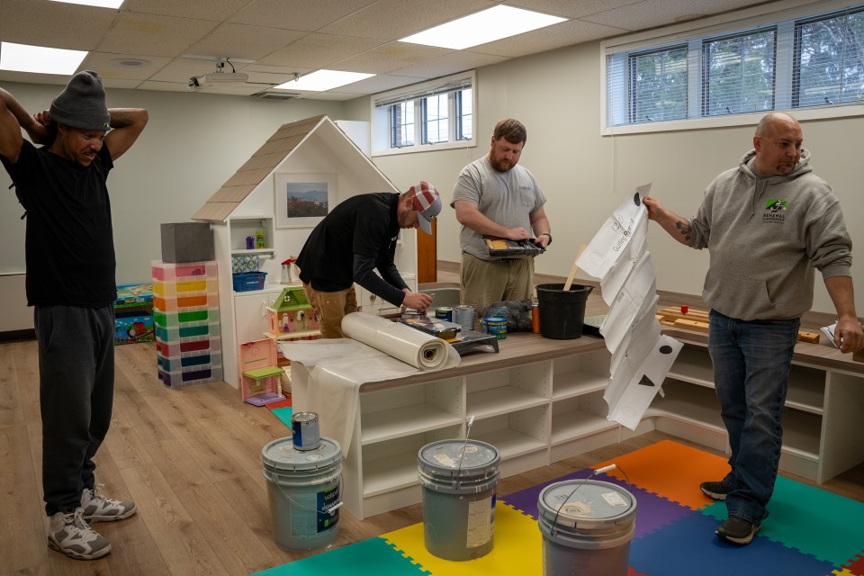 Volunteers from Renewal by Andersen of Roanoke help paint the Ronald McDonald House play room.