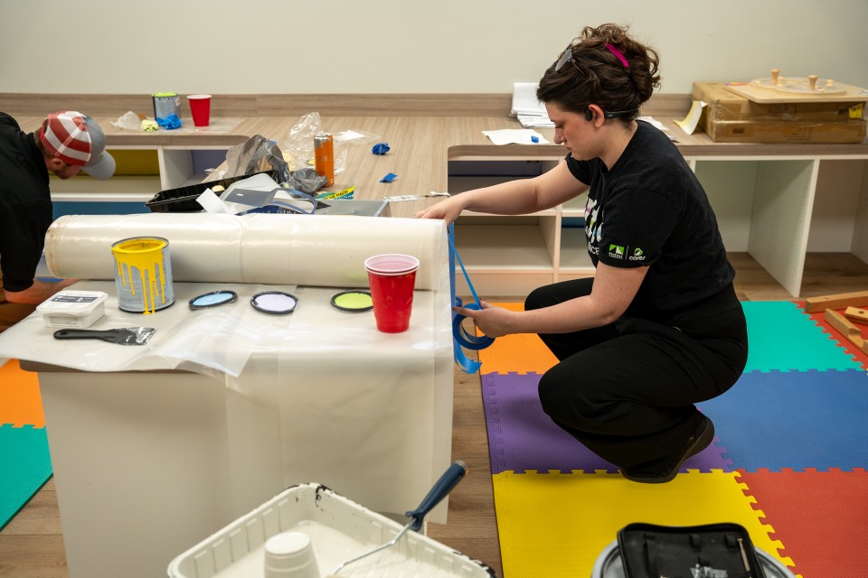 Volunteers from Renewal by Andersen of Roanoke help paint the Ronald McDonald House play room.