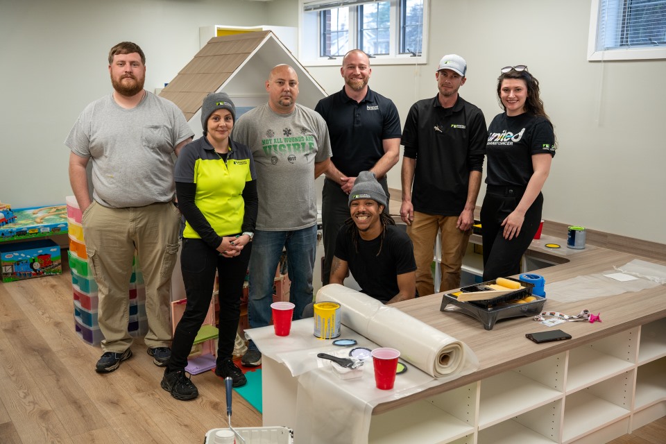 Volunteers from Renewal by Andersen of Roanoke help paint the Ronald McDonald House play room.