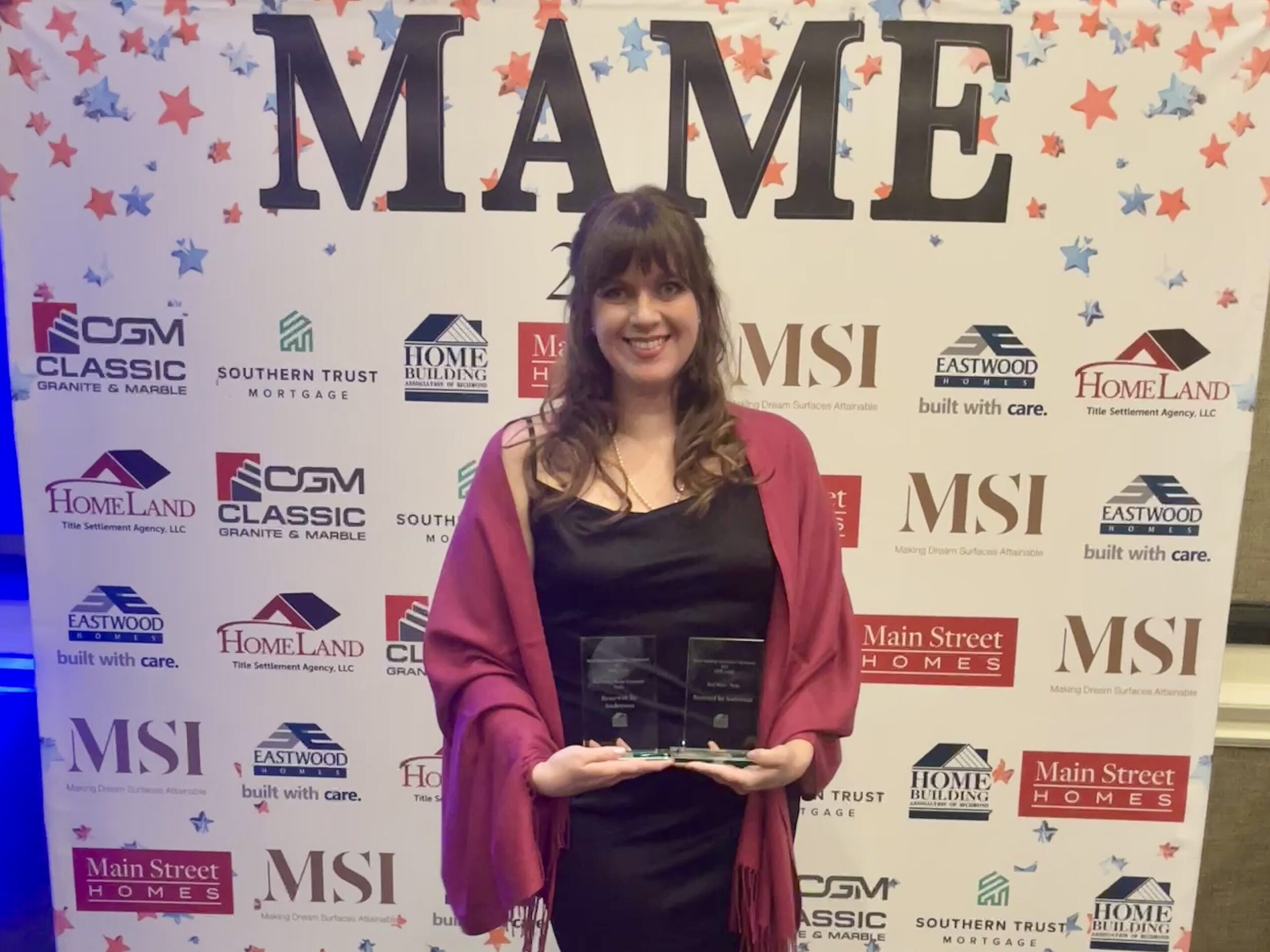 Erica Dodson holding two HBAR awards won by Renewal by Andersen of Central Virginia.