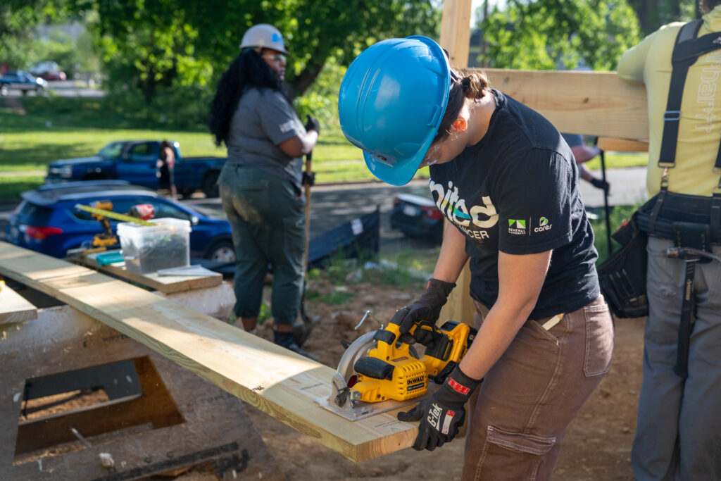 Renewal by Andersen of Roanoke team member using a saw at Habitat for Humanity