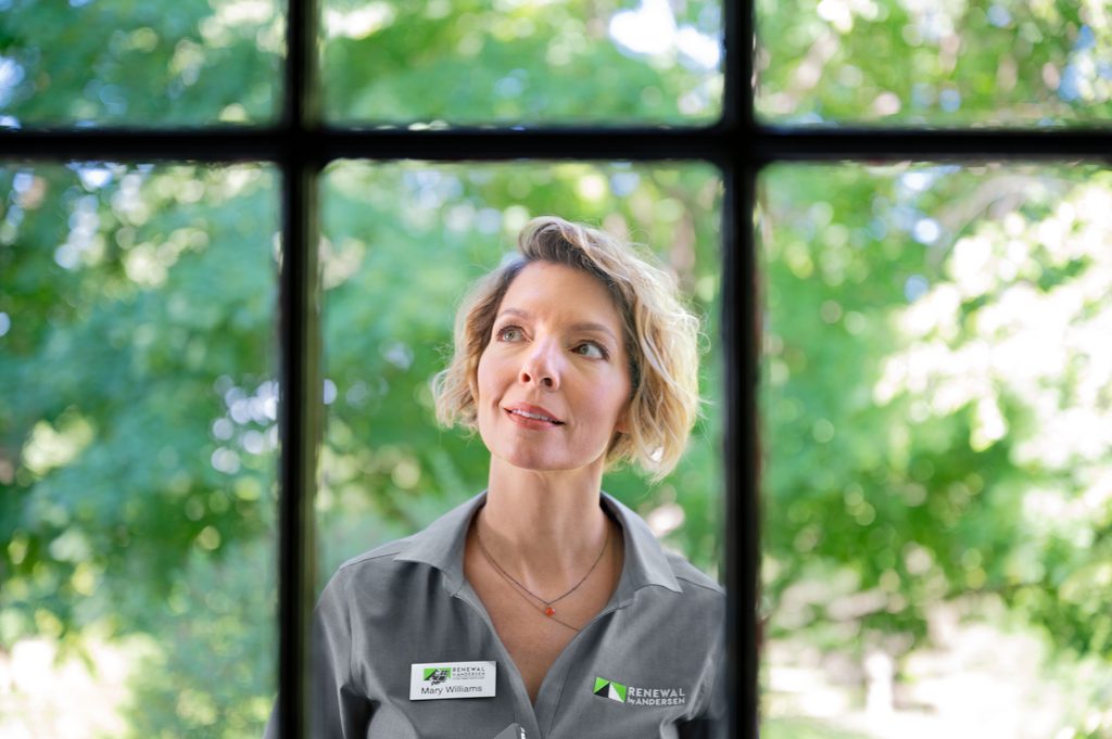 Renewal by Andersen Brand Ambassador looking through a window.