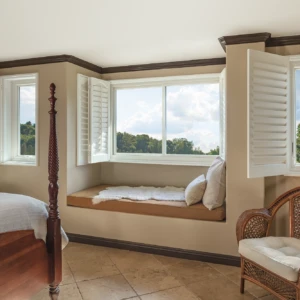 Windows in a tan bedroom with the shutters open
